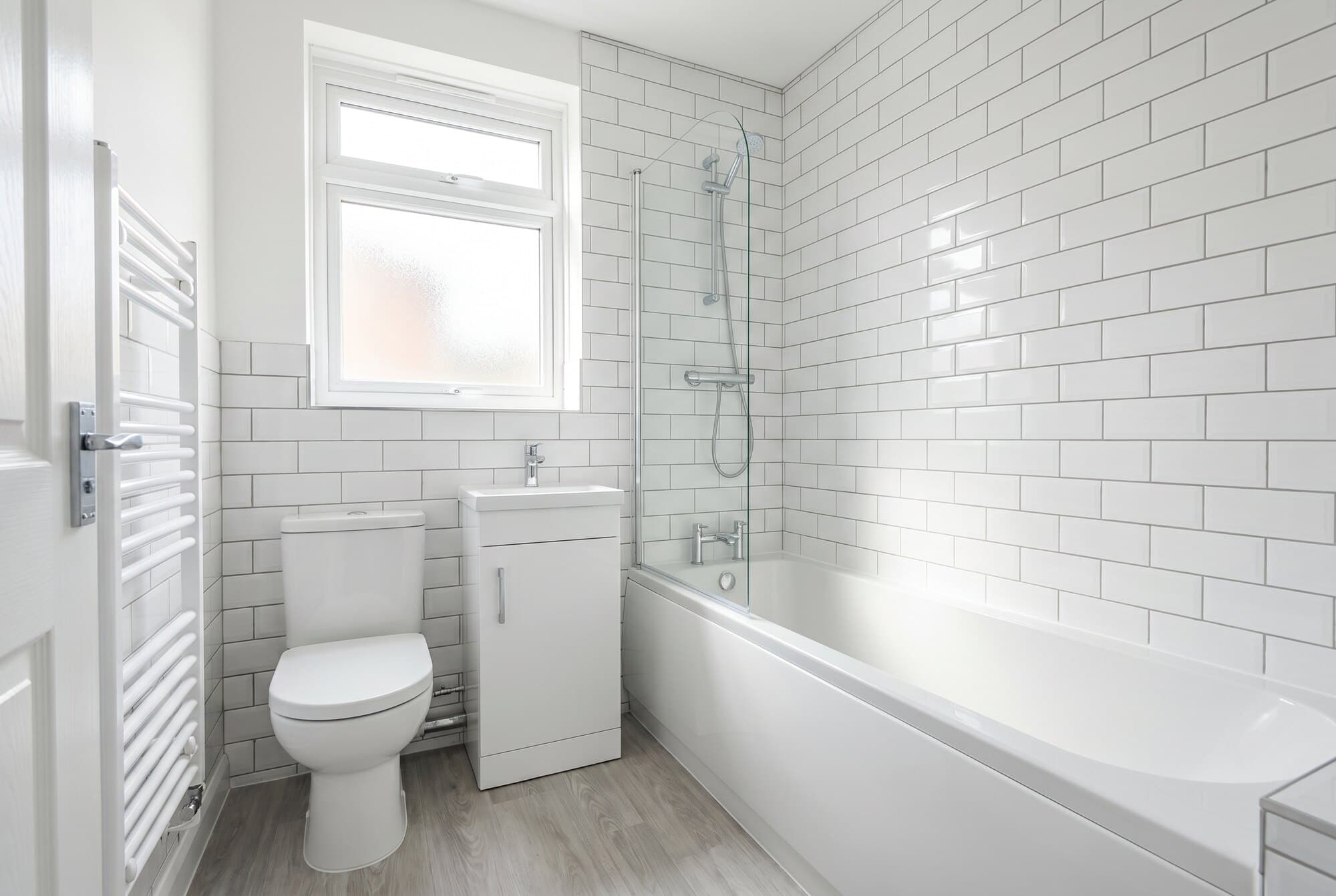 A bright, clean budget-refresh bathroom with a simple modern white suite.