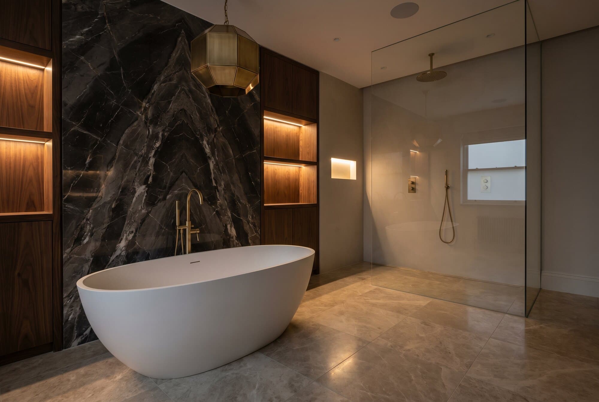 A luxury bathroom with a statement freestanding bath and natural stone surfaces.