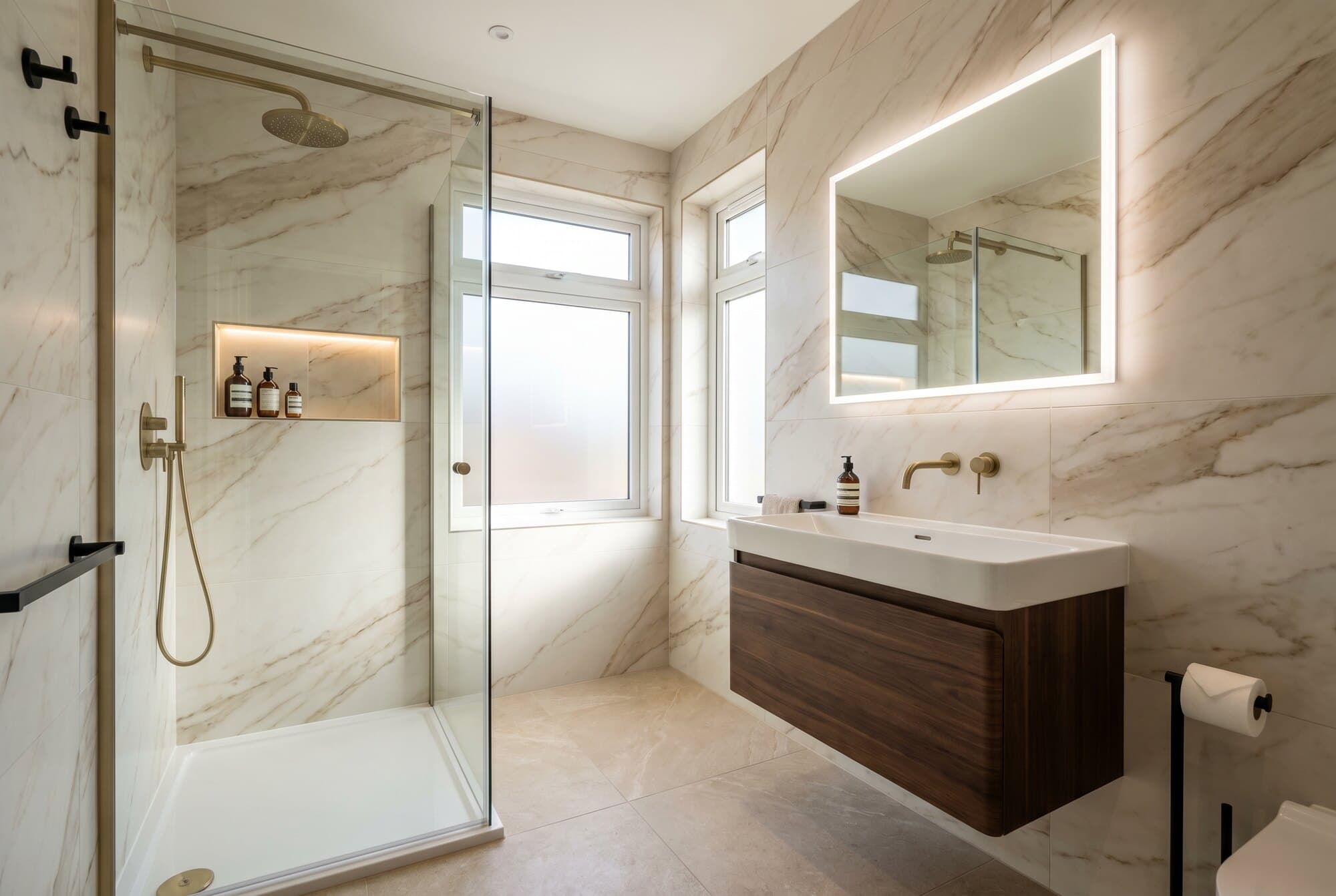 A premium bathroom with feature tiling, a rainfall shower and designer lighting.